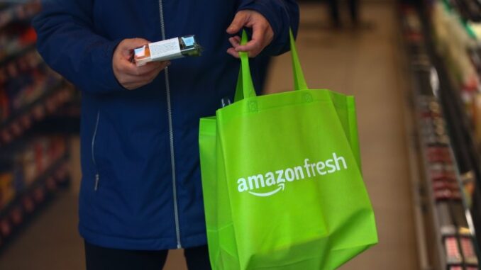 Amazon UK under investigation for suspected payment delays A shopper takes a product off a shelf at the Amazon.com Inc. Amazon Fresh convenience store in the Ealing area of London