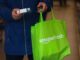 A shopper takes a product off a shelf at the Amazon.com Inc. Amazon Fresh convenience store in the Ealing area of London