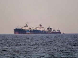 Two large oil tankers are positioned side by side in the sea