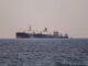Two large oil tankers are positioned side by side in the sea