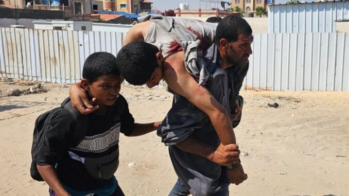 Israel kills 45 in latest shooting of Gazans seeking food, Palestinians help carry a man who was injured while waiting for aid in Rafah, in the southern Gaza Strip on June 16 2025