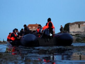 An inflatable dinghy prepares to set out into the English Channel from Ambleteuse, near Calais
