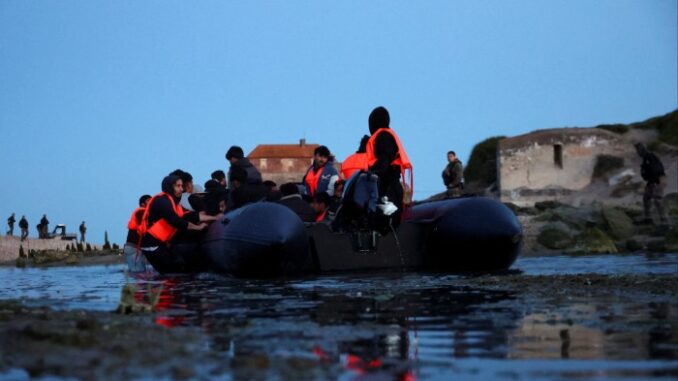An inflatable dinghy prepares to set out into the English Channel from Ambleteuse, near Calais
