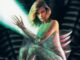 poster art showing a human/alien hybrid woman seated with spikes coming out of her back